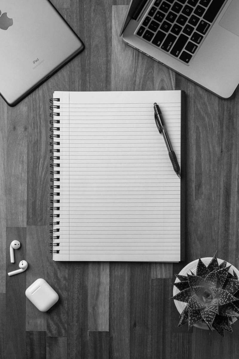 Un cuaderno en blanco con un bolígrafo negro encima