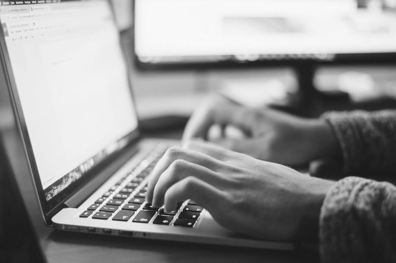 Manos escribiendo en el teclado de un portátil