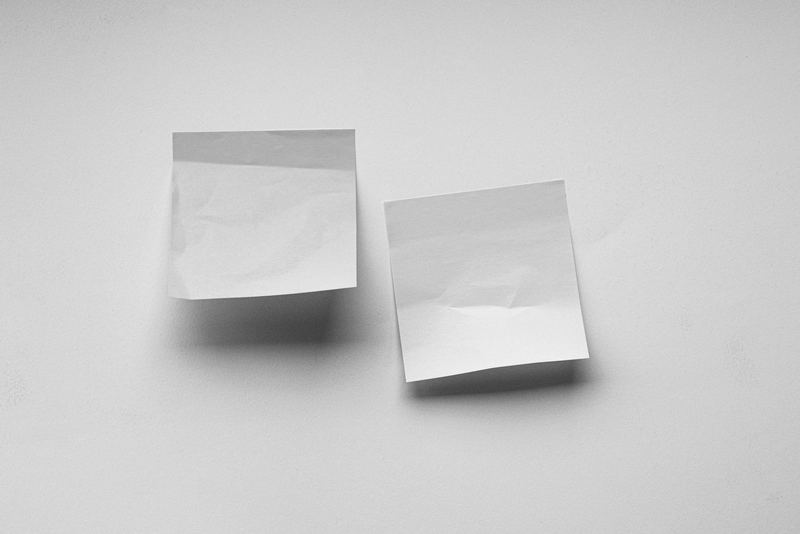 Dos notas adhesivas en blanco pegadas a una pared